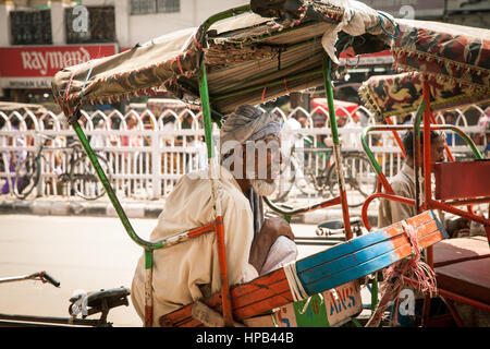 Delhi, India - September 18, 2014: Rickshaw resting on his vehicle on the street of Old Delhi, India on September 18, 2014. Stock Photo