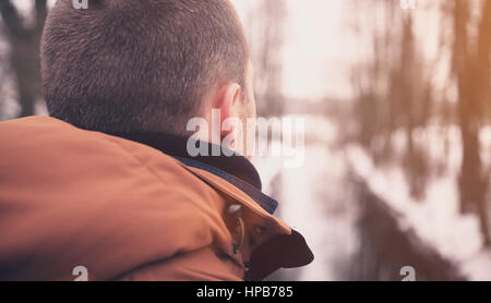 Closeup traveler looking ahead. Travel retro concept. View behind mans head on winter background. Soft focus of man head.
