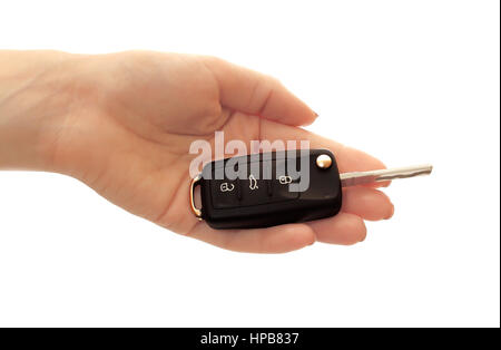 Car ignition key in woman hand over white background. Closeup of black car key in hand isolated on white. Car sales concept. Stock Photo