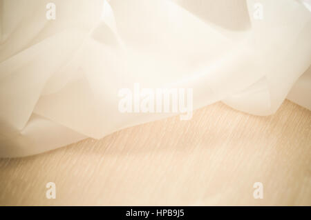 beige tulle shines on the wooden table Stock Photo