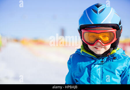 Cheerful young skier wearing safety helmet and goggles Stock Photo