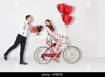 Man with Valentines presents and girl on the bike Stock Photo