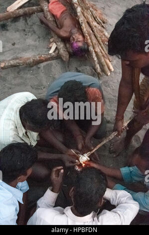 PURI, INDIA:  Relatives light the fire for the cremation ritual in Swargadwar crematorium in Puri, India. This sacred site witnesses huge crowds of devotees, which go on increasing every year.  HOW TO LICENCE THIS PICTURE: Please contact me via e-mail at simon.padovani@gmail.com or call +39 3921454211 for prices and terms of copyright. First Use Only ,Editorial Use Only, All repros payable, No Archiving. ©Simone Padovani Stock Photo