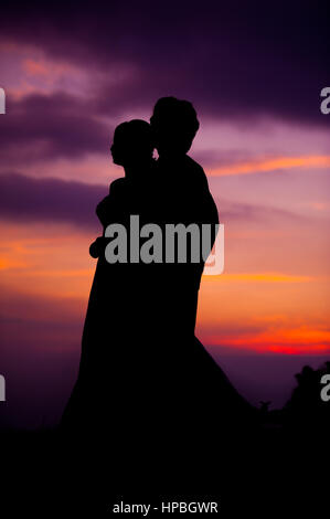 Silhouette of Embracing Asian Bride and Groom at Sunset Stock Photo - Alamy