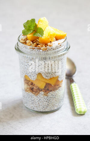 Chia pudding with peach and mango slices in a jar Stock Photo