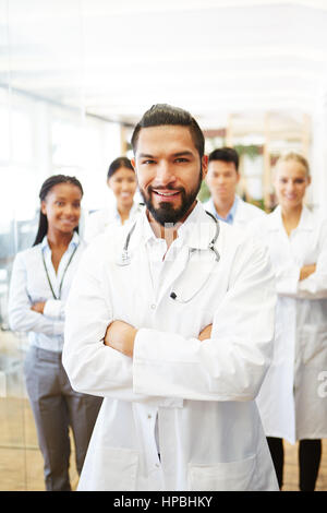 Confident man as doctor with successful team in hospital Stock Photo
