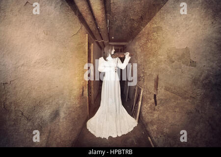 Horror ghost girl appears in an old building. Creepy movie scene Stock Photo