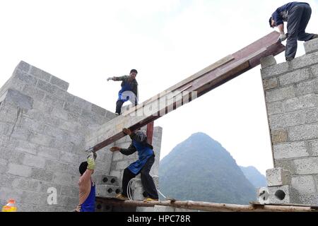(170221) -- DAHUA, Feb. 21, 2017 (Xinhua) -- Villagers build a house in Nongteng Village of Qibainong Township in Dahua Yao Autonomous County, south China's Guangxi Zhuang Autonomous Region, Jan. 7, 2017. 'Cursed by devils' -- that is what the locals say about Qibainong. Named after the rugged karst landforms that surround it, the township has been identified as one of the most inhospitable places on earth by UN officials. However, change is expected soon. Local governments are building roads for every village with more than 20 households. Relocation has been proposed for those who live in ext Stock Photo