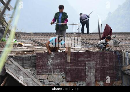 (170221) -- DAHUA, Feb. 21, 2017 (Xinhua) -- Villagers build a house in Nongteng Village of Qibainong Township in Dahua Yao Autonomous County, south China's Guangxi Zhuang Autonomous Region, Jan. 7, 2017. 'Cursed by devils' -- that is what the locals say about Qibainong. Named after the rugged karst landforms that surround it, the township has been identified as one of the most inhospitable places on earth by UN officials. However, change is expected soon. Local governments are building roads for every village with more than 20 households. Relocation has been proposed for those who live in ext Stock Photo