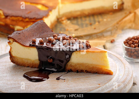 Cheesecake slice with melted chocolate and chocolate balls Stock Photo