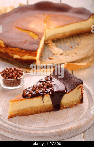 Cheesecake slice with melted chocolate and chocolate balls Stock Photo