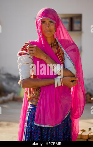 RAJASTHAN, INDIA - NOVEMBER 20, 2016: An Unidentified Rajasthani woman wearing a traditional dress with pink sari and ornaments on her hands. Stock Photo