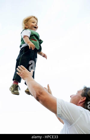 Model released , Vater wirft kleinen Jungen in die Luft - father throws sun in the sky Stock Photo