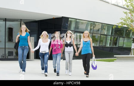 Model released , Fuenf jugendliche Maedchen spazieren Hand in Hand nebeneinander - five teenage girls walking hand in hand Stock Photo
