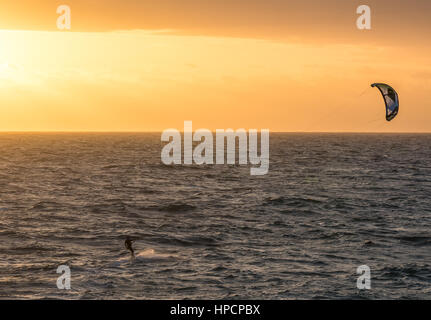 A man kitesurfing during a sunset in Indian ocean in Perth, Western Australia Stock Photo