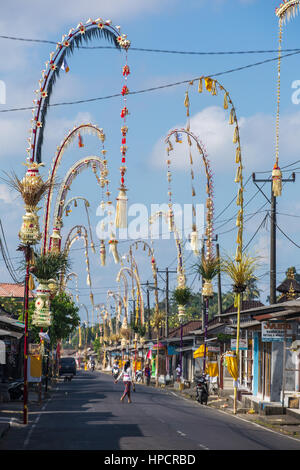 Bali, Indonesia - September 5, 2016: Bali Penjors, decorated bamboo poles along the village street in Bali, Indonesia. Penjors are placed outside Bali Stock Photo