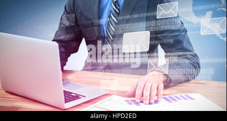 Businessman using laptop while checking graph  against email graphics against earth Stock Photo