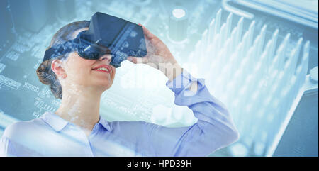 Low angle view of businesswoman using virtual reality headset against micro parts of mother board Stock Photo