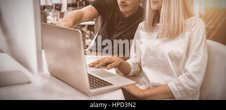 Graphic designers working over laptop at desk in office Stock Photo