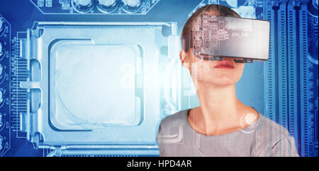 Close up of woman using virtual reality simulator against close-up of circuit board Stock Photo