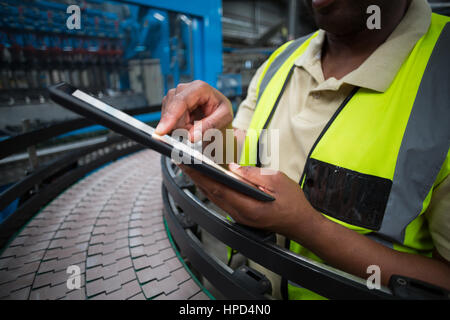 Mid section of factory worker using digital tablet in the factory Stock Photo