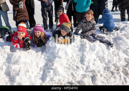Kids in snow watching The First ICE Dragon Boat Race Event in North America held on the Rideau Canal on Dow's Lake in Ottawa, Ontario,Canadain Stock Photo