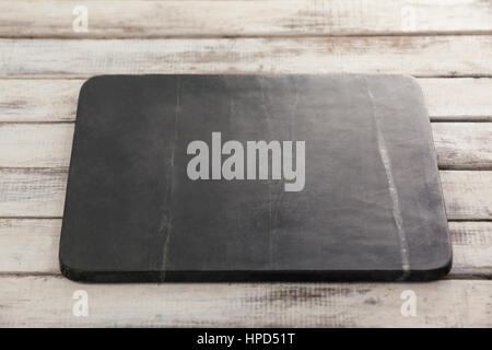 Black slate plate against wooden background Stock Photo