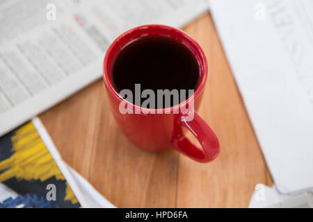 Coffee served in red mug on wooden table Stock Photo