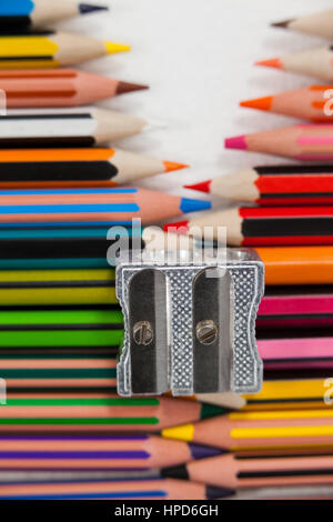 Close-up of colored pencils and sharpener on white background Stock Photo