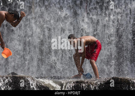 Young boys having fun in a waterfall. Bali, Indonesia. Stock Photo