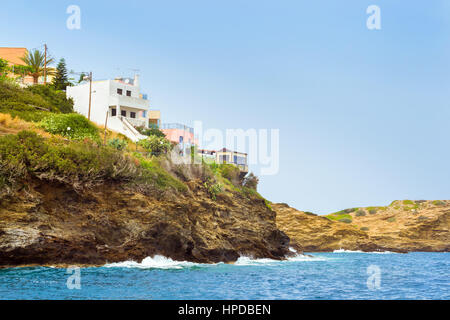 Waves near rocky shore. Sea view from cliff on resort architecture and excellent beach separated by rocky stone ledges. Village Bali - vacation destin Stock Photo