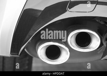 Double car exhaust pipe detail in black and white. Pollution. Horizontal Stock Photo