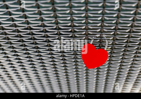 Red heart shaped love lock isolated on a metal fence on a bridge in Bristol, UK Stock Photo