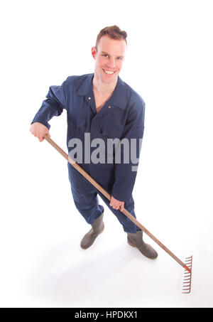Mature farmer holding a shovel and posing with a pile of burlap sacks ...