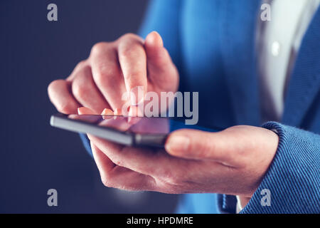 Businesswoman using mobile phone and sending SMS message Stock Photo