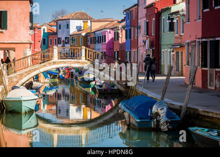 traditional houses lining the canal in burano can be seen painted in bright colours Stock Photo