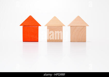 Unique red house made out of toy blocks among wooden blocks. Stock Photo