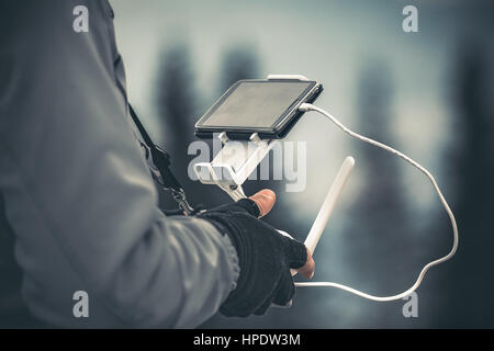 Man operating a drone using a remote controller. Winter holidays in mountains. Close up picture. Bukovel, Carpathians, Ukraine, Europe. Exploring beau Stock Photo