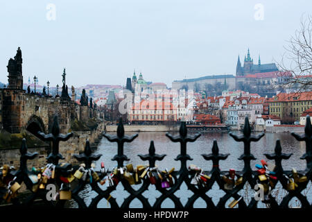 View of Vltava river, Prague castle, Mala Strana and Charles Bridge from the other side of the river over the fence with love locks. Stock Photo