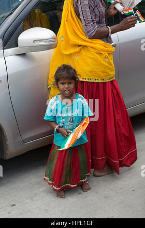 Poor indian girl child selling India flags at a traffic stop Stock Photo