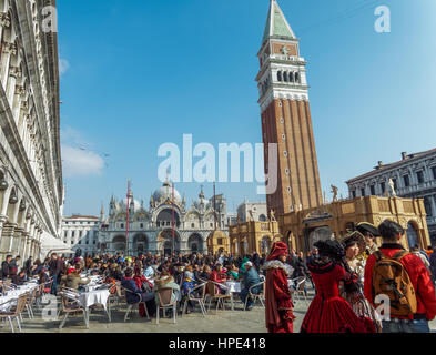 Crowd sitting at coffee shops at PIazza San Marco before Saint Marks Basilica during the Venice 2017 Carnival. Stock Photo
