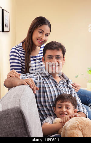 Portrait of mother and father with son on sofa Stock Photo