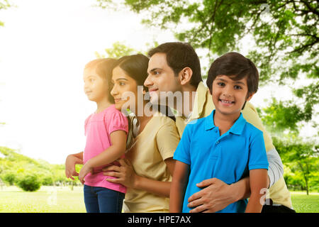 Young couple sitting with their daughter and son in a park Stock Photo