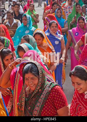 Women in a procession making its way through the streets of Deogarh in Rajasthan, India, as part of wedding celebrations Stock Photo