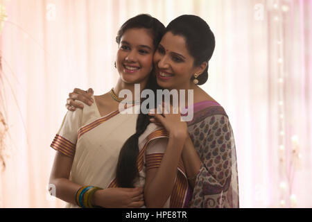 Smiling teenage daughter in sari with her mother Stock Photo