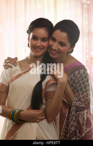 Smiling teenage daughter in sari with her mother Stock Photo