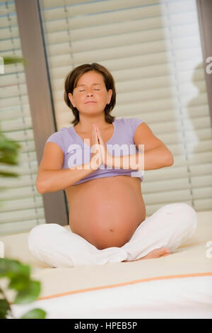 Model released , Schwangere Frau macht Jogauebung - pregnant woman does yoga