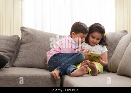 Brother and sister using digital tablet Stock Photo