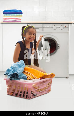 Young girl loading the washing machine Stock Photo