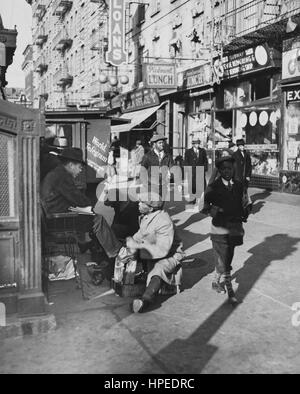 View of Lenox Avenue, Harlem, New York at 135th Street, showing businesses, pedestrians and shoe-shine stand, March 23, 1939. Stock Photo